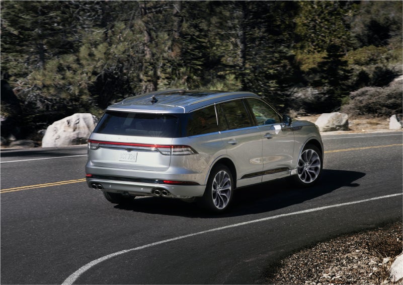 A 2023 Lincoln Aviator® Grand Touring model is shown being driven on a tight turn of a mountain road | Wallace Lincoln in Fort Pierce FL