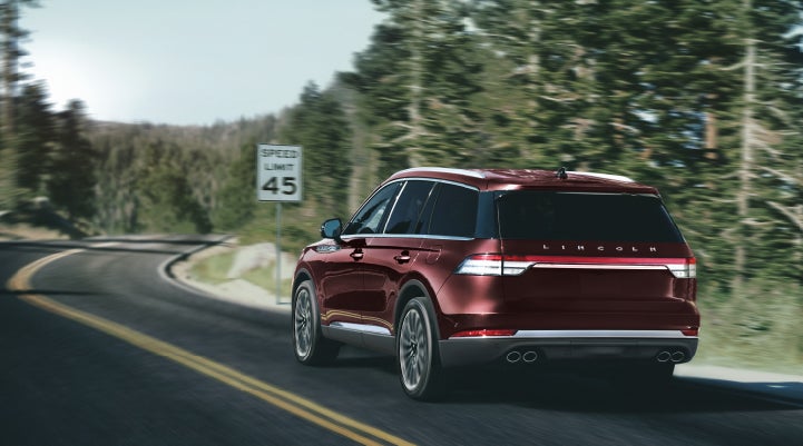 A 2024 Lincoln Aviator® SUV is being driven on a winding mountain road | Wallace Lincoln in Fort Pierce FL