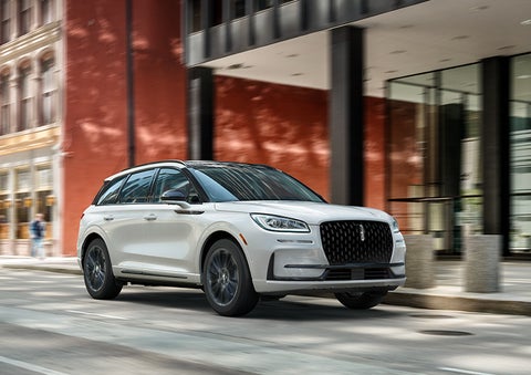 The 2024 Lincoln Corsair® SUV with the Jet Appearance Package and a Pristine White exterior is parked on a city street. | Wallace Lincoln in Fort Pierce FL